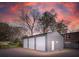 View of a three-car metal storage building with gravel parking and side Personal door at 706 White Oak Dr, Charleston, SC 29407