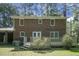 Backyard view of the brick home with a wooden deck and lush green lawn and mature trees at 710 S Magnolia St, Summerville, SC 29483
