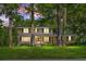 Charming two-story brick home featuring a covered front porch and a lush green lawn with mature trees at 710 S Magnolia St, Summerville, SC 29483