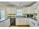 Well-lit kitchen with white cabinets, dark countertops, and modern appliances at 710 S Magnolia St, Summerville, SC 29483