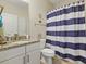 Bathroom featuring granite countertop, a toilet, and shower/tub combo with a blue and white striped shower curtain at 7101 Bowen Corner Ave, Hanahan, SC 29410