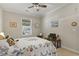 Comfortable bedroom with ceiling fan, window, neutral walls, and colorful floral patterned bedspread at 7101 Bowen Corner Ave, Hanahan, SC 29410