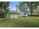 Wide view of backyard showing well-kept lawn, trees, and back of house at 7993 Malden Ave, North Charleston, SC 29420