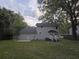 View of a two-story home with a spacious backyard, showcasing a well-maintained lawn and outdoor living space at 7993 Malden Ave, North Charleston, SC 29420