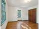 A bedroom featuring hardwood floors, white walls, green trim, and a single window at 810 Creekside Dr, Mount Pleasant, SC 29464