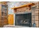Detailed view of the brick fireplace with wooden mantle and doors, complete with hearth and fire tools at 810 Creekside Dr, Mount Pleasant, SC 29464
