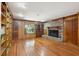 Spacious living room featuring hardwood floors, a cozy brick fireplace, and built-in bookshelves for ample storage at 810 Creekside Dr, Mount Pleasant, SC 29464