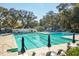 Community pool featuring lap lanes, lounge chairs, umbrellas, mature trees, and a pool house at 810 Creekside Dr, Mount Pleasant, SC 29464