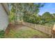 A fenced backyard is seen with grass, trees, and landscaping, offering a private and natural outdoor space at 8524 Brookforest Dr, Charleston, SC 29406