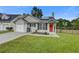 Charming single-story home with vinyl siding, attached garage, well-kept lawn, and a vibrant red front door at 8524 Brookforest Dr, Charleston, SC 29406