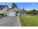 Charming single-story home featuring vinyl siding, an attached garage, well-kept lawn, and a cozy front porch at 8524 Brookforest Dr, Charleston, SC 29406