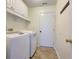Clean laundry room with white washer and dryer, storage cabinets, and access door at 8524 Brookforest Dr, Charleston, SC 29406