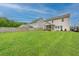 Well-maintained backyard with lush green lawn, privacy fence, and a view of the home's exterior and screened-in porch at 9767 Black Willow Ln, Ladson, SC 29456