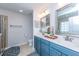 Bathroom featuring double sinks, blue vanity, and a glass-enclosed shower at 9767 Black Willow Ln, Ladson, SC 29456