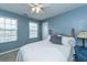 Comfortable bedroom with blue walls, a white bed, two windows, and ceiling fan at 9767 Black Willow Ln, Ladson, SC 29456