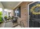 Inviting front porch with wicker seating and a decorative wreath on the front door, offering a cozy welcome at 9767 Black Willow Ln, Ladson, SC 29456