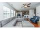 Bright living room with a large sectional sofa, ceiling fan, and views into the kitchen, perfect for entertaining at 9767 Black Willow Ln, Ladson, SC 29456