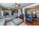 Open concept living room features hardwood floors, a gray sofa, and a view to the dining area at 9767 Black Willow Ln, Ladson, SC 29456