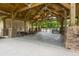 Outdoor community lodge area with picnic tables and stone pillars, perfect for gatherings, and pool view at 9767 Black Willow Ln, Ladson, SC 29456