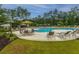Community swimming pool surrounded by lounge chairs and umbrellas, set amidst lush greenery, offering a serene recreation space at 9767 Black Willow Ln, Ladson, SC 29456