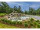 Scenic water feature with cascading waterfalls and lush landscaping at the community entrance at 9767 Black Willow Ln, Ladson, SC 29456