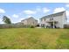 Expansive backyard showcasing a spacious lawn, covered patio, outdoor seating, and privacy fencing at 102 Bolsena Ct, Summerville, SC 29486