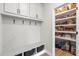 Mudroom showcases a bench with baskets, coat hooks, and pantry with shelving at 102 Bolsena Ct, Summerville, SC 29486