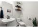 Stylish powder room features a pedestal sink, modern fixtures, and floating shelves at 102 Bolsena Ct, Summerville, SC 29486