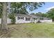 Quaint single-story house with white brick, black shutters, and a lush green lawn at 105 Evatt Dr, Goose Creek, SC 29445