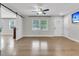 Bright living room with hardwood floors, window, fan, television, and barn-style door at 105 Evatt Dr, Goose Creek, SC 29445