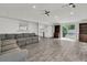 Spacious living room with grey sofa, sliding glass door, and wood-look tiled flooring at 105 Evatt Dr, Goose Creek, SC 29445