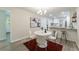 Dining area with a white table set on a red rug, next to an open kitchen with bar seating at 106 Kent Cir, Ladson, SC 29456