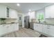 Open kitchen with stainless steel appliances, granite countertops, and sleek white cabinets at 106 Kent Cir, Ladson, SC 29456