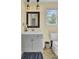 Bathroom featuring a vanity with a gray cabinet, a decorative mirror, and tan-colored walls at 108 Mourning Dove Dr, Bonneau, SC 29431