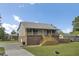 The side view shows a home with a brick foundation, and a metal roof, a spacious driveway, and a well-manicured lawn at 108 Mourning Dove Dr, Bonneau, SC 29431