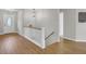 Hallway with wooden floors leading to stairs and a doorway, showcasing bright, neutral decor at 108 Mourning Dove Dr, Bonneau, SC 29431