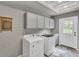 Bright laundry room featuring modern washer and dryer, ample cabinetry and convenient sink at 108 Mourning Dove Dr, Bonneau, SC 29431
