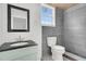 Stylish bathroom with gray tiles, a black-framed mirror, and modern fixtures at 108 Williamsburg Ct, Goose Creek, SC 29445