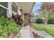 Charming front porch with lush landscaping, brick accents, and a view of the well-maintained yard at 108 Williamsburg Ct, Goose Creek, SC 29445