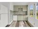 Compact kitchen featuring light green cabinets, stylish wallpaper, and stainless steel appliances at 108 Williamsburg Ct, Goose Creek, SC 29445