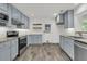 Well-lit kitchen featuring blue cabinets, stainless steel appliances, and granite countertops for a modern look at 108 Williamsburg Ct, Goose Creek, SC 29445