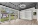 Stylish sunroom with wall-to-wall windows and a decorative tray ceiling, leading to a peaceful backyard at 108 Williamsburg Ct, Goose Creek, SC 29445