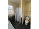 Full bathroom showing window with blinds, toilet, shower with a shower curtain, and tiled flooring at 1110 Pickett St, Moncks Corner, SC 29461