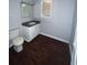 Bathroom featuring a white vanity and toilet against blue walls, highlighted by dark wood-look flooring at 1110 Pickett St, Moncks Corner, SC 29461
