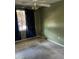 A carpeted bedroom with a ceiling fan, window with dark floral curtains, and dull green walls at 1110 Pickett St, Moncks Corner, SC 29461