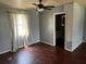 The bedroom features wood floors, neutral walls, and a view of the outside through a window with sheer curtains at 1110 Pickett St, Moncks Corner, SC 29461