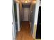 Hallway with hardwood flooring, showing doors to rooms and the refrigerator in the kitchen at 1110 Pickett St, Moncks Corner, SC 29461