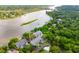 Aerial view of luxurious waterfront community with lush green trees and a boat in water at 112 Waterfront Plantation Dr, Charleston, SC 29412