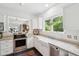 Bright kitchen with stainless steel appliances, granite counters, and a farmhouse sink by a garden window at 112 Waterfront Plantation Dr, Charleston, SC 29412