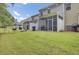 A vast backyard with well-maintained green grass, leading up to the screened in porch at 113 Alpine Rd, Summerville, SC 29485